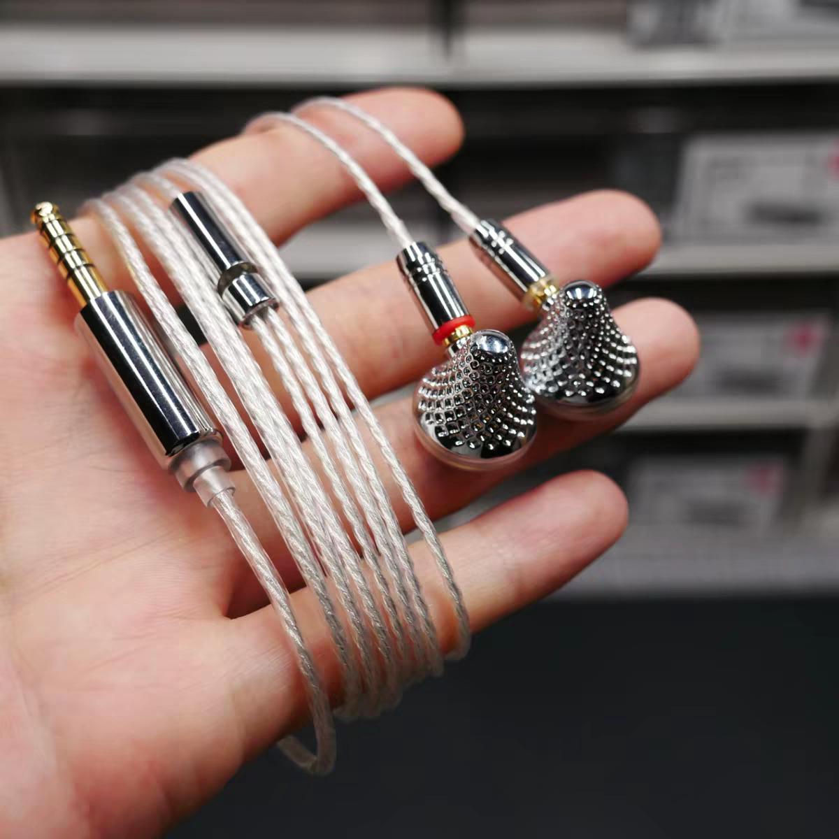 Earbuds and balanced cable shown in hand